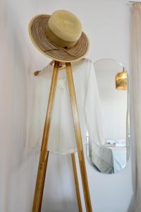 a straw hat on a tripod next to a mirror at Kryni Deluxe Houses in Adamas