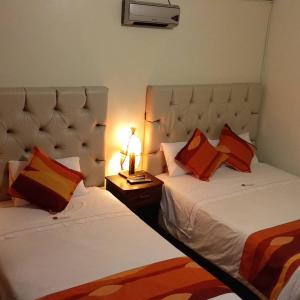 - une chambre avec deux lits et une lampe sur une table dans l'établissement Andino, à Machu Picchu