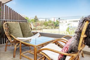 een balkon met 2 stoelen en een glazen tafel bij INF32J- Apotel Infinity by Roomservices in Estepona