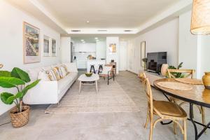 een woonkamer met een witte bank en een tafel bij INF32J- Apotel Infinity by Roomservices in Estepona