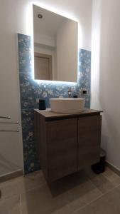 y baño con lavabo y espejo. en Le stanze di Efesto en Linguaglossa