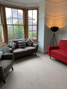 uma sala de estar com dois sofás e um sofá vermelho em 3 Newboro Terrace, Conwy em Conwy