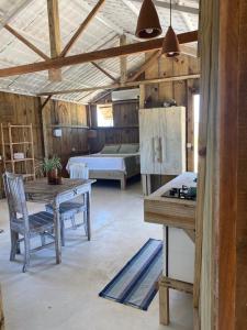 Habitación con mesa, sillas y cama en Cabana Cachandó, en Corumbau