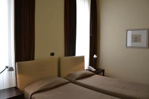 a bedroom with a bed and a window at Albergo Alla Posta in Trieste