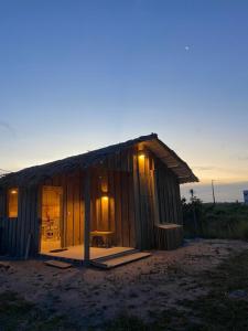 ein kleines Holzhaus mit eingeschaltetem Licht in der Unterkunft Cabana Cachandó in Corumbau
