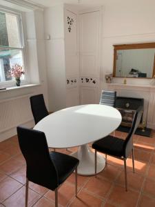 a dining room with a white table and chairs at 3 Newboro Terrace, Conwy in Conwy