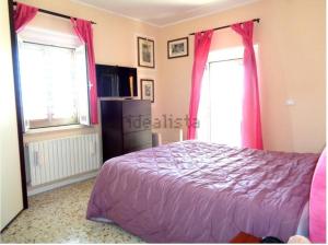 - une chambre avec un lit violet et 2 fenêtres dans l'établissement Relax vicino Ascoli Piceno, à Ascoli Piceno