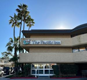 un edificio con un cartel que lee la posada del Pacífico en The Pacific Inn en Seal Beach