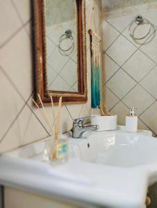 een wastafel met een spiegel en een tandenborstel bij JAVA GEVA zen living in Kalamaki