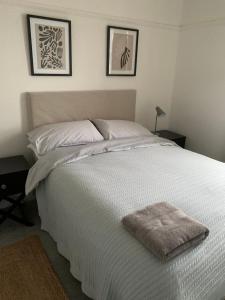 1 cama blanca en un dormitorio con 2 cuadros en la pared en 3 Newboro Terrace, Conwy, en Conwy