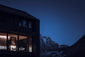 a building with chairs and a view of a mountain at Amus Chalets Dolomites - Luxury Chalets South Tyrol in Anterselva di Mezzo