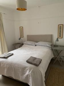 a bedroom with a white bed with two towels on it at 3 Newboro Terrace, Conwy in Conwy