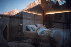 1 dormitorio con 1 cama en una habitación en Amus Chalets Dolomites - Luxury Chalets South Tyrol, en Anterselva di Mezzo