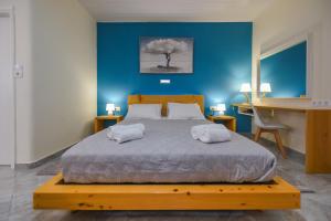 a bedroom with a large bed with a blue wall at Sea Salt Apartments in Samos