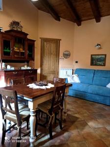 uma sala de estar com uma mesa e um sofá azul em Casa Coccinella Valdieri - Codice CIR00423300008 em Valdieri