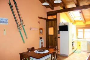 uma cozinha com uma mesa e um frigorífico branco em Casa Coccinella Valdieri - Codice CIR00423300008 em Valdieri