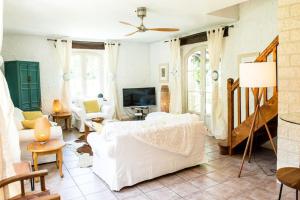 een woonkamer met een witte bank en een tv bij Beautiful Home with Large Gardens and Heated Pool in Sauveterre-la-Lémance