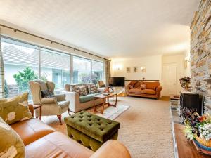 a living room with furniture and a large window at Pennard in Tuckingmill