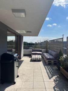 a patio with a couch and a table on a balcony at Apartament Księcia Janusza in Warsaw