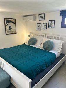 a bedroom with a large bed with a blue comforter at Casa con piscina e vista mare dal giardino in Fanusa