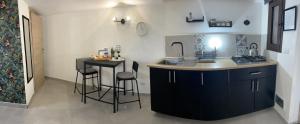 a kitchen with a sink and a counter with stools at Casa con piscina e vista mare dal giardino in Fanusa