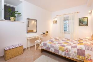 a bedroom with a bed and a table and a mirror at Nila's Place in Dubrovnik