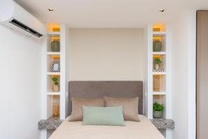 een slaapkamer met een bed met een grijs hoofdeinde en planken bij Studio Luxo Itaim - Homax in Sao Paulo