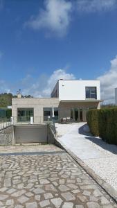 a building with a stone walkway in front of it at Sanxenxo Casa Rial 47 con PISCINA CLIMATIZADA in Sanxenxo