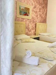 a room with two beds with towels on them at Eleni Guest House in Sarandë
