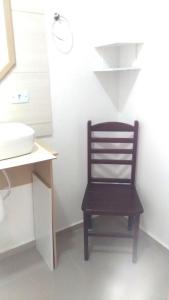 uma cadeira de madeira sentada numa casa de banho ao lado de um lavatório em Pousada Montanha da Pedra Grande em Atibaia