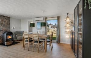a dining room with a table and a fireplace at 3 Bedroom Lovely Home In Hvide Sande in Bjerregård