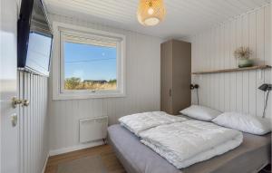 a bedroom with a large bed and a window at 3 Bedroom Lovely Home In Hvide Sande in Bjerregård