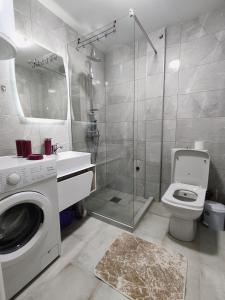 La salle de bains est pourvue d'une douche et d'un lave-linge. dans l'établissement Msm-2, à Pristina