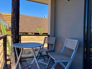 2 sillas, mesa y 2 sillas en el porche en Coquenas del Valle, en Valle de Guadalupe