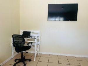 a desk with a chair and a monitor on a wall at Navapart in San Isidro