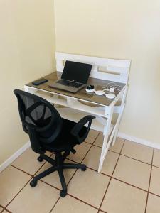 a desk with a laptop and a chair on it at Navapart in San Isidro