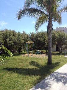 una palmera y un parque infantil en Irene Villa en Ierápetra