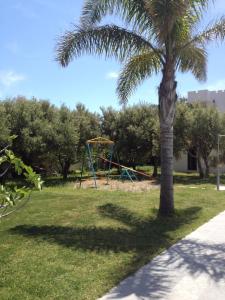 a palm tree and a playground in a park at Irene Villa in Ierapetra