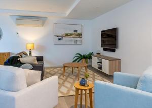 a living room with white furniture and a tv at Salt 7 Spacious Luxury in Sorrento walk to the beach in Sorrento