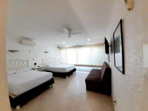 1 dormitorio con 1 cama, 1 sofá, 1 cama y 1 silla en Placentero depa en mar caribe!, en Cancún