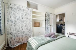 a bedroom with a bed with a blanket and a curtain at Modern 1BR Condo - near Trinity Bellwoods Park in Toronto