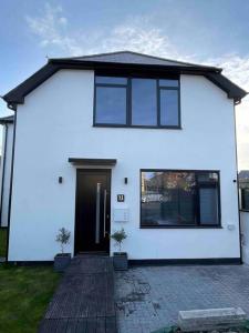 a white house with a black door and windows at Brand New Luxury 2 Bedroom House in Parkstone