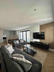 a large living room with a couch and a table at Brand New Luxury 2 Bedroom House in Parkstone