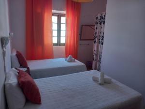 a hotel room with two beds and a window at Caravela in Lagos