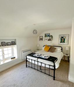 a bedroom with a bed and a clock on the wall at SEREN cottage by the sea in Llangadwaladr
