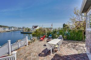 a table and chairs on a brick patio next to the water at Toms River Vacation Rental with On-Site Dock! in Toms River