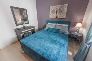 a bedroom with a blue bed and a mirror at Sea Salt Village House in Samos