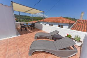 a patio with chairs and a table on a roof at Sea Salt Village House in Samos