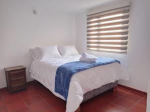 - une chambre blanche avec un lit et une fenêtre dans l'établissement Villa del Prado, à Villa de Leyva