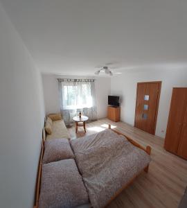 a bedroom with a bed and a living room at Apartament Muszelka in Puck